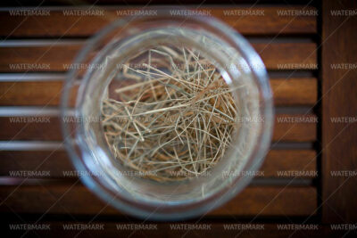 A glass of water with some straw in it