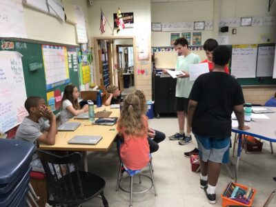 Students presenting projects in classroom.
