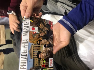 A person holding up a picture of philadelphia marathon.