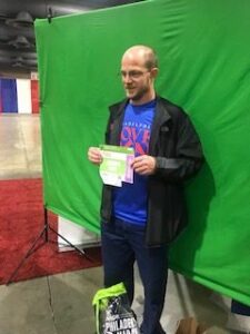 A man standing in front of a green screen.