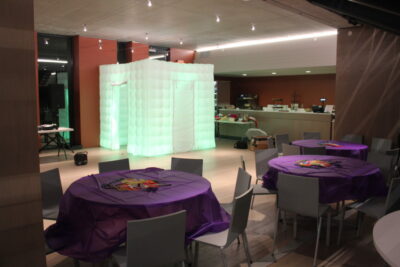 A room with purple tables and chairs, and an inflatable wall.
