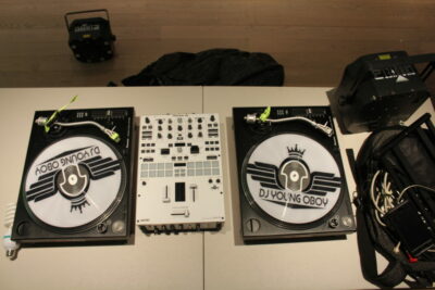 Two dj decks and a mixer on top of a table.