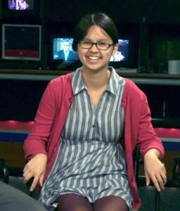 Smiling young woman in a red cardigan.