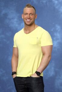 Here's an alt tag for the image: Smiling man in yellow shirt, headshot.