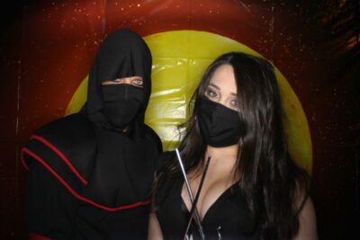 A man and woman in black costumes posing for the camera.