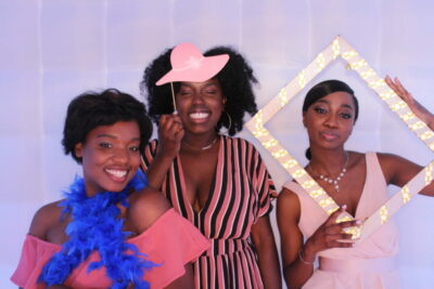 Three women posing for a photo booth picture.