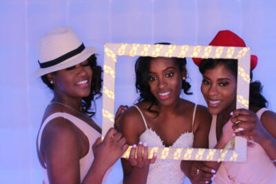 Three women posing for a picture in front of a mirror.