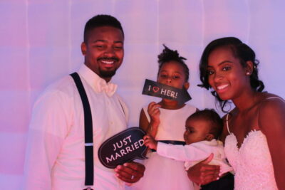 A family posing for a photo in front of a pink backdrop.
