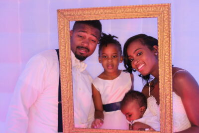 A family posing for a picture in a frame.