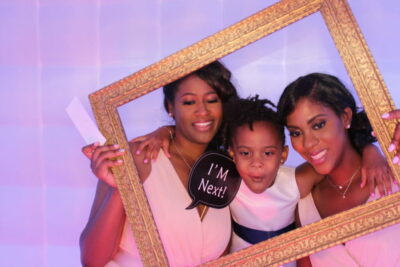 A group of women holding up a picture frame.