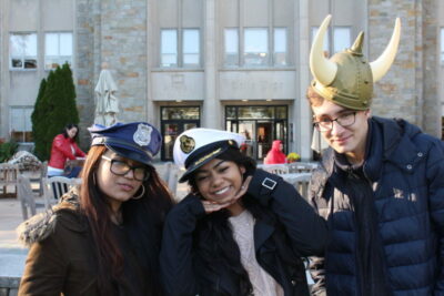 Three people wearing hats and posing for a picture.