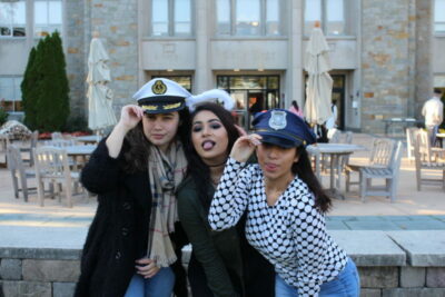 Three women posing for a picture in front of a building.