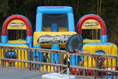 A bunch of kids playing in an inflatable obstacle course.